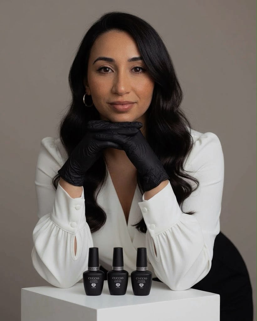 Retrato de Carolina Alves de blusa branca e luvas pretas com esmaltes no estúdio